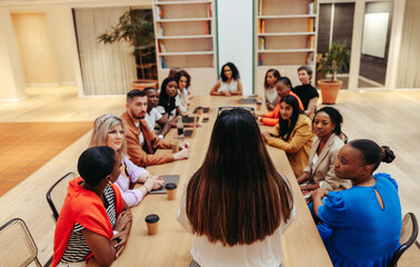 Businesswoman leading a group discussion in a modern conference room setting