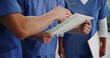 © peopleimages.com - Doctor, team and hands with folder for medical procedure, planning or checkup on patient clinic records at hospital. Closeup, nurses or healthcare employees with documents for discussion on diagnosis