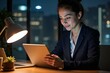 © SimpleDesignStudio - Professional Woman Working Late Night Office Job Using Laptop, Focused and Dedicated, Modern Office Setting with City View