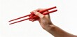 © Png - Video - Photo - A hand holding vibrant red chopsticks against a clean white background, perfect for culinary and dining themes.