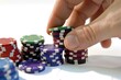 © Vii - A person placing a stack of poker chips on a table, a popular casino game scene