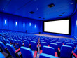 © Vectplus - Modern cinema interior with large blank screen, blue decor and empty seats before a movie screening in the daytime