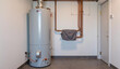 © Andrey - Tall metal water heater in utility room