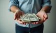 © Vitalii - Man is holding bundle of dollar bills in his hands. The concept of wealth and abundance
