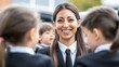 © AUAChanel - Smiling female professional interacting with children in formal attire at outdoor event, showcasing warmth, engagement, and a positive atmosphere in a contemporary setting