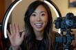 © Zaleman - A young Asian woman with a manicure uses a camera and ring light in studio to shoot a video tutorial for a beauty blog
