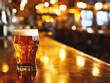 © DailyGood - A glass of beer on the table on the pub bar bokeh background