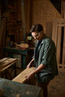 © Bliss - A dedicated female carpenter meticulously works with wood, crafting pieces in her serene workshop space.