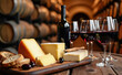 Tabla de quesos con pan y vino tinto en bodega con barricas al fondo e iluminación cálida.
