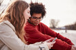 © MACO - Gen Z couple outside beside a river hanging out and having fun together. Munich, Germany