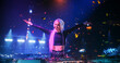 © Gorodenkoff - Young Beautiful Female DJ Playing Dance Music Sets, EDM, Techno, House Tracks at a Nightclub with Devoted Music Fans. Neon Lights and Excited Crowd Create a Party Atmosphere at a Festival
