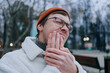 © wifesun - Man in glasses and winter clothes feeling toothache in park on cold day, showing pain and discomfort, reflecting frustration of dental issue