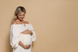 © New Africa - Portrait of beautiful pregnant woman on beige background, space for text