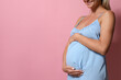 © New Africa - Pregnant woman on pink background, closeup. Space for text