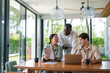 © Dorde - Three diverse young adults focus on a project, using tablets and laptops in a well-lit office, embodying teamwork and technology integration in a corporate setting.