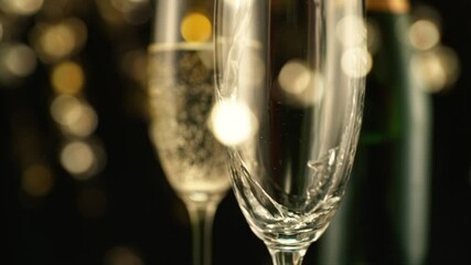 Fototapete - Super Slow Motion of Pouring Champagne Wine on Black Background with Flashing Blur Spot Lights. Filmed on High Speed Cinema Camera, 1000fps. Speed Ramp Effect.