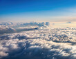 © Arda ALTAY - A stunning aerial view shows fluffy white clouds floating above Earth's landscape against a deep blue sky.
