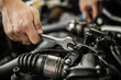 © zphoto83 - A mechanic repairs an engine using a wrench in an auto shop during the day while focusing on the intricate details of the components