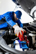 © zphoto83 - Mechanic in blue uniform performs battery jump start on vehicle at automotive workshop during daytime