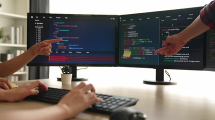 Slow motion back end software developer engineer for computer programming working together on debugging writing computing code, solving complex algorithms display on monitor in office. Burgeoning