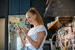© Geber86 - Young woman holding smartphone in modern kitchen