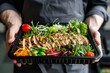 © Vorda Berge - Man holding a plastic black container box with healthy food