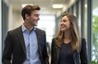 © Surachetsh - Two teen man and woman businesspeople are smiling and conversing at a corporate event, both wearing lanyards exhibition card. The background is blurred of trade show event.