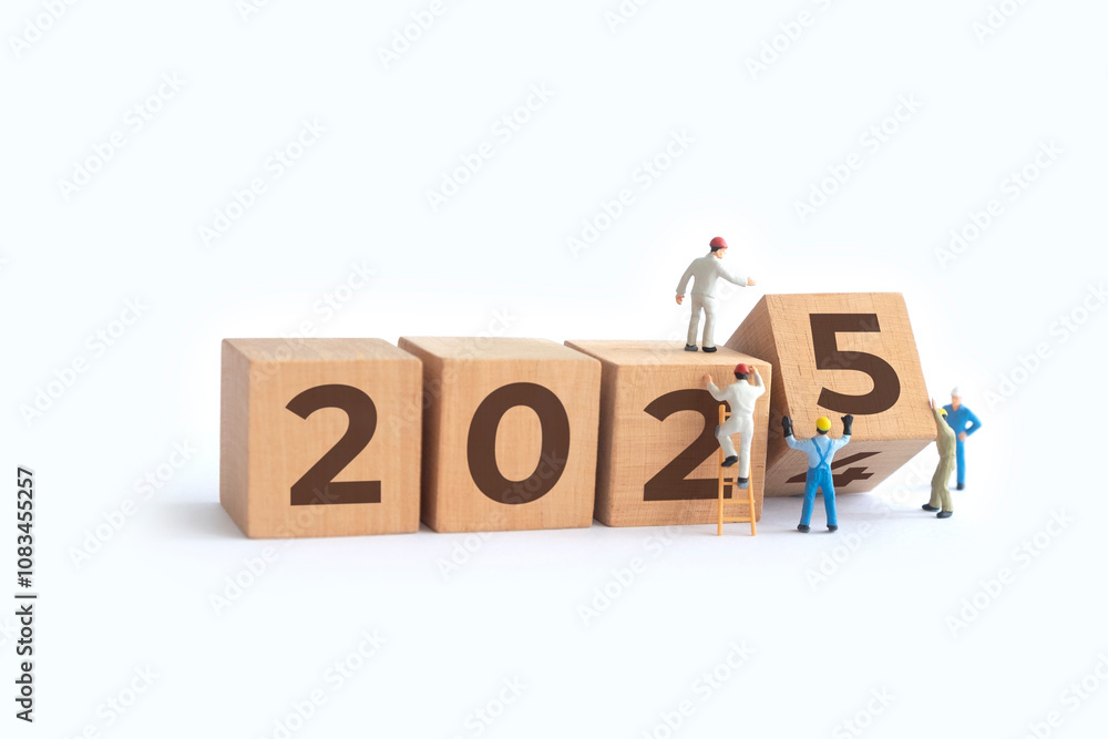 Transitioning from 2024 to 2025 with wooden blocks and miniature people ...