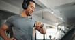 © peopleimages.com - Fitness, gym and man with time, music and heart rate check with treadmill and runner stats. Stopwatch, run and wellness app with exercise, training and pulse tracking for workout with monitor tech