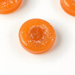 © Qrryferry - A swirl-shaped orange jelly candy with glittering sugar crystals, isolated on white