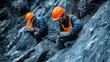 © Peerarut - A close-up of mining workers and geologists inspecting rock formations with geological tools and safety equipment, representing the integration of geology and safety in modern mining practices