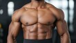 © Cherrin - A muscular man showcases his well-defined chest and abs in a fitness-focused environment.