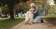 © peopleimages.com - Love, dog walking and kiss with old woman in park for training, adventure and health. Animal care, support and morning with person and Labrador pet in nature for bonding, guide and wellness.