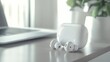 © Athirat - A pair of wireless earphones rest on a desk, ready to be used.