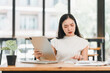 © PRIME STOCK LAB - Focused woman working with tablet and papers in modern office