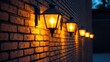 © Biancaart - Illuminated wall-mounted lanterns on a brick wall at night.