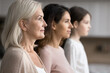 © fizkes - Profile side faces view of serious attractive grandmother posing with grown up daughter and little granddaughter standing together in row, three generations of women, family unity, bonding and ties