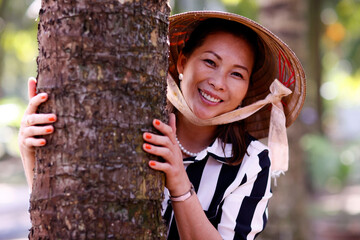 Wall Mural - Vietnamese woman wearing a tradional palm leaf conical hat. Portrait Tan Chau. Vietnam.