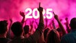 © Rona_65 - Crowd celebrating with hands raised at a vibrant event, illuminated by a bright '2025' display.