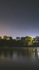 Wall Mural - Night Sky Above River. 4k Hyperlapse. From Dusk To Dawn. Stars Float Across Sky. Night Sky Turns Into Morning. Meteors Fly Across The Night Sky. Dawn Is Coming. Meditation By The Water. Calmness And