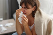 © New Africa - Woman wrapped in blanket suffering from sinusitis at home