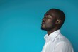 © darshika - African businessman in white shirt on blue background.