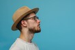 © darshika - Serious hipster guy in hat and glasses on blue background