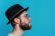 © darshika - Serious hipster guy in hat and glasses on blue background