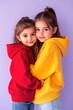 © Ева Поликарпова - Two young girls embracing on a purple background