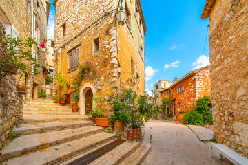 Wall Mural - Colorful medieval stone buildings along the Grand Rue main street through the hilltop village of Tourrettes-sur-Loup, France, in the Alpes-Maritimes region of Southern France.	