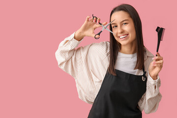 Wall Mural - Female hairdresser with scissors and brush on pink background