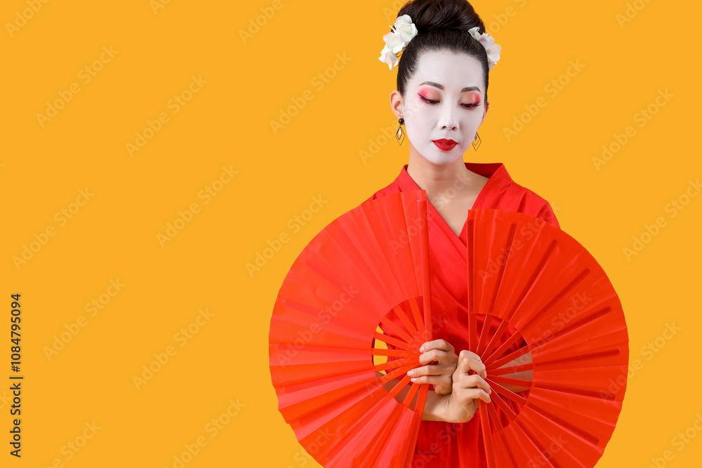 Beautiful young geisha with fans on yellow background