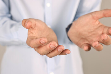 Wall Mural - Man holding something on grey background, closeup