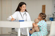 © Pixel-Shot - Female pediatrician working with cute little girl at table in clinic